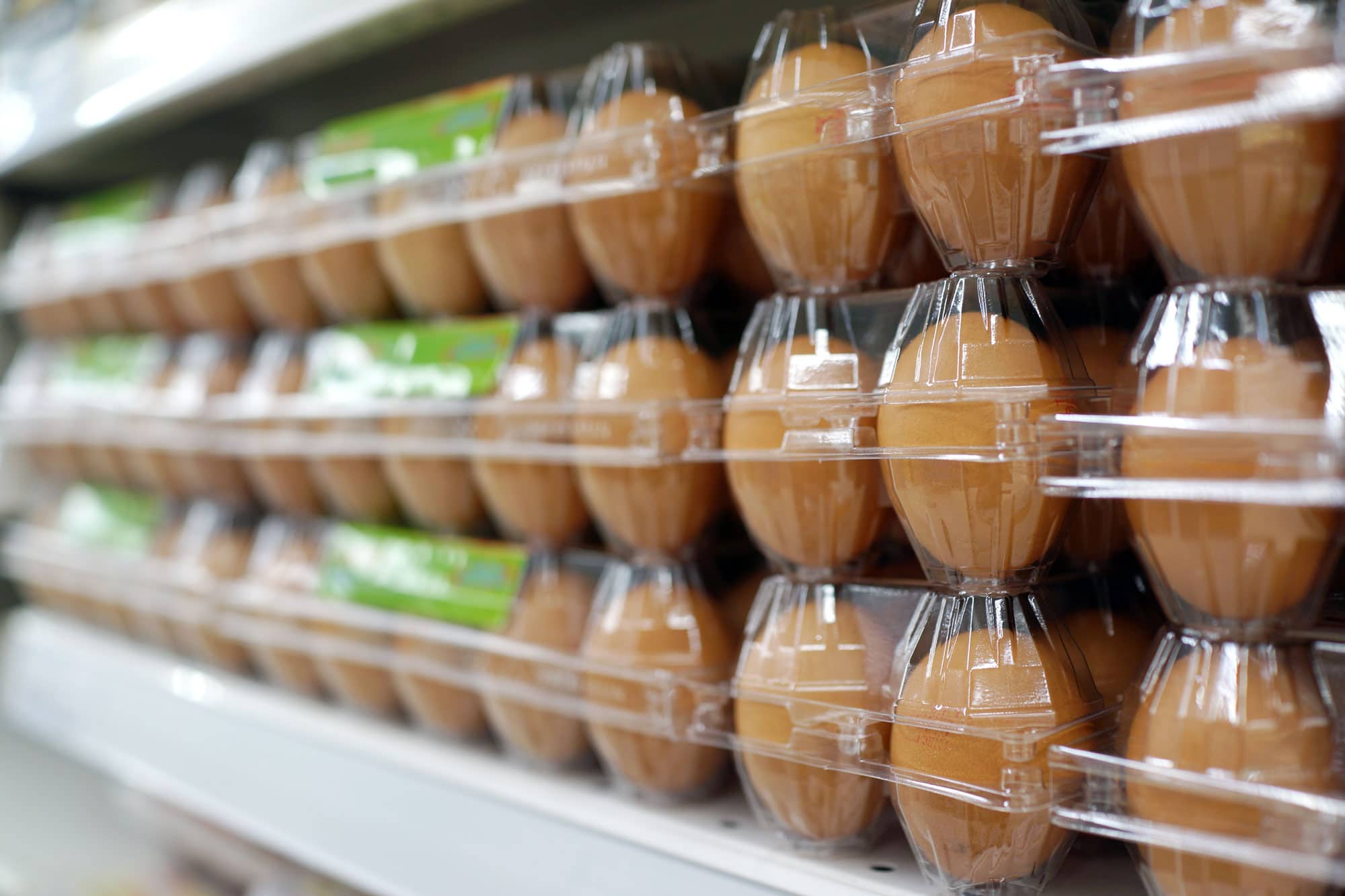 Brown eggs in plastic containers on grocery shelf
