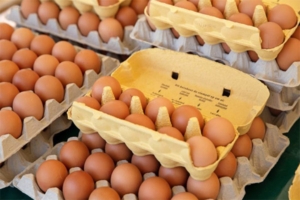 Image showcases several cartons of brown eggs stacked atop one another, prepared for sale by Eggs Unlimited. This photo is featured in an article discussing how egg prices reached their third record high in 2022, highlighting the market dynamics Eggs Unlimited navigates.