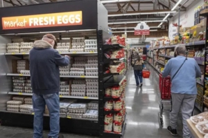 Image features grocery shoppers carefully selecting the most affordable eggs, accompanying an article in which Eggs Unlimited was mentioned, titled 'School lunch, eggs, and airfare: Why inflation soared for 10 items in 2022'